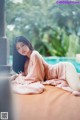 A woman laying on a bed next to a swimming pool.