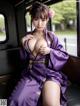 A woman in a purple kimono sitting on a bus.