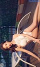 A woman in a white bikini laying on a wooden deck.