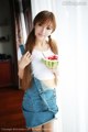 A woman holding a slice of watermelon in her hand.