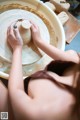 A woman is making a pot on a potter's wheel.