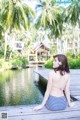 A woman in a blue and white striped bikini sitting on a dock.