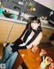 A woman sitting at a table in a kitchen.