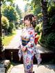 A woman in a kimono standing in a garden.